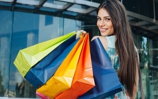 Attractive woman posing with shopping bugs in front of the shopping center