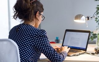 Beautiful young woman working with laptop in her office.