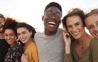 Portrait Of Smiling Young Friends Walking Outdoors Together